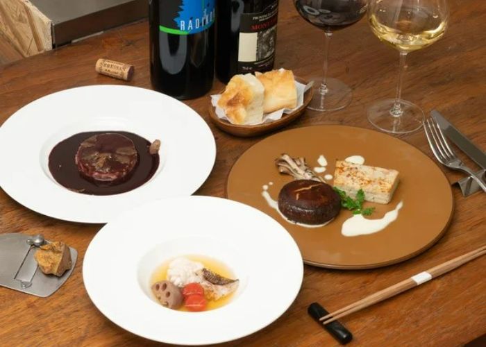 A selection of dishes on a table at La Luce, served alongside a bottle of wine.